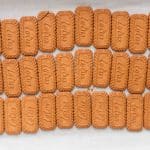 36 Biscoff cookies arranged side by side on a parchment lined baking sheet