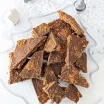 Biscoff toffee pieces on a clear christmas tree shaped platter with silver christmas decorations around