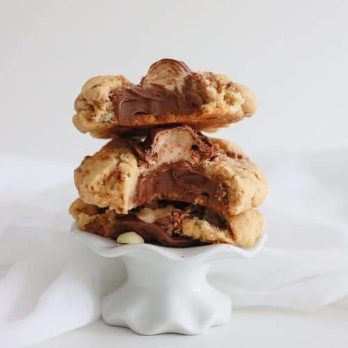 3 Nutella stuffed Kinder cookies on top of each other with bites taken out to show the nutella stuffed center