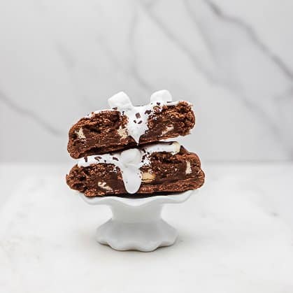 Easy hot chocolate marshmallow cookie cut in half and stacked on top of eachother to show marshmallow fluff oozing out inside