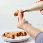fill cannoli shells with cannoli filling using piping bag