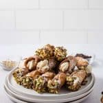 final cannoli's dipped in pistachios and chocolate chips on plate