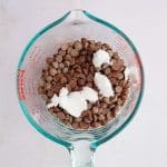 chocolate and coconut oil in measuring cup to melt in microwave for snickers date bark