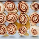 Cinnamon rolls covered and rising until puffy in baking dish