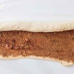Dough rolled tightly into a log for cinnamon rolls