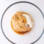 cashew butter, coconut flour and maple syrup in mixing bowl for cashew butter Reese eggs