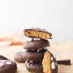 Cashew Butter Reeses Eggs stacked on top of each other; one bitten open to show the inside