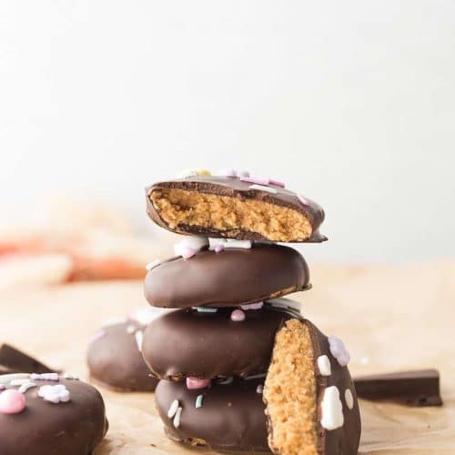 Cashew Butter Reeses Eggs stacked on top of each other; one bitten open to show the inside