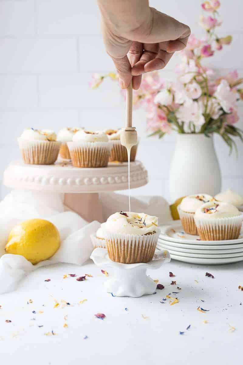 closeup on honey lemon cupcake being drizzled with honey