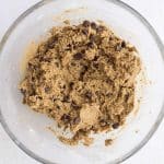 high protein chickpea blondies batter with chocolate chips added and mixed in glass mixing bowl