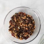chopped nuts, seeds, coconut, chia seeds, and protein powder in large clear mixing bowl
