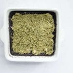 cooked brownies in pan with kataifi pistachio layer on top