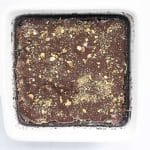 final Dubai chocolate avocado brownies in pan sprinkled with pistachio crumbs