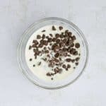 heated cream over chocolate chips in bowl