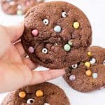 hand holding up a protein monster mash cookie with others in background