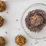 pumpkin spice energy balls being rolled in cacao nibs coating