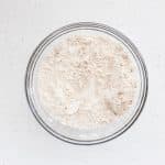 dry ingredients mixed together in clear glass bowl on white background