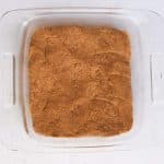 Pressing protein bar dough evenly into an 8×8-inch parchment-lined baking pan.