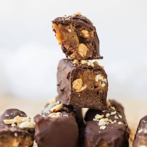 2 high protein snickers bars cut in half stacked on top of 4 full size bars
