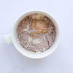 Ingredients for healthy Snickers protein mug cake including protein powder, almond flour, peanut butter.