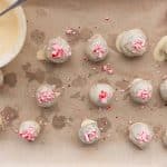Decorating healthy chocolate peppermint protein balls with crushed peppermint candies.