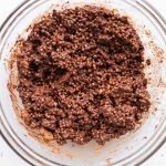 Melted chocolate and Biscoff mixture in a bowl with puffed quinoa mixed.