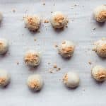 White chocolate coated gingerbread energy bites setting on parchment paper