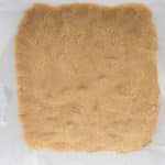 Twix cookie base pressed evenly into a glass baking dish