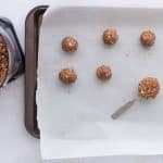 Using tablespoon to scoop and roll the Snickers protein ball dough into bite-sized balls