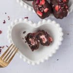 Strawberry Cheesecake Stuffed Date cut in half to see filling in white heart bowl