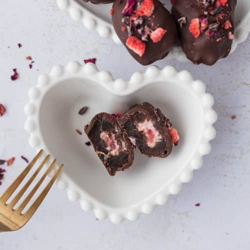 Strawberry Cheesecake Stuffed Date cut in half to see filling in white heart bowl