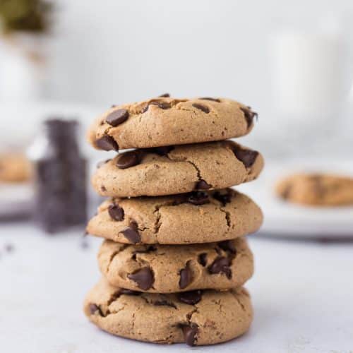 5 chocolate chip protein cookies stacked on top of eachother with soft chewy centers