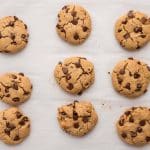 Freshly baked chewy chocolate chip protein cookies cooling on baking sheet