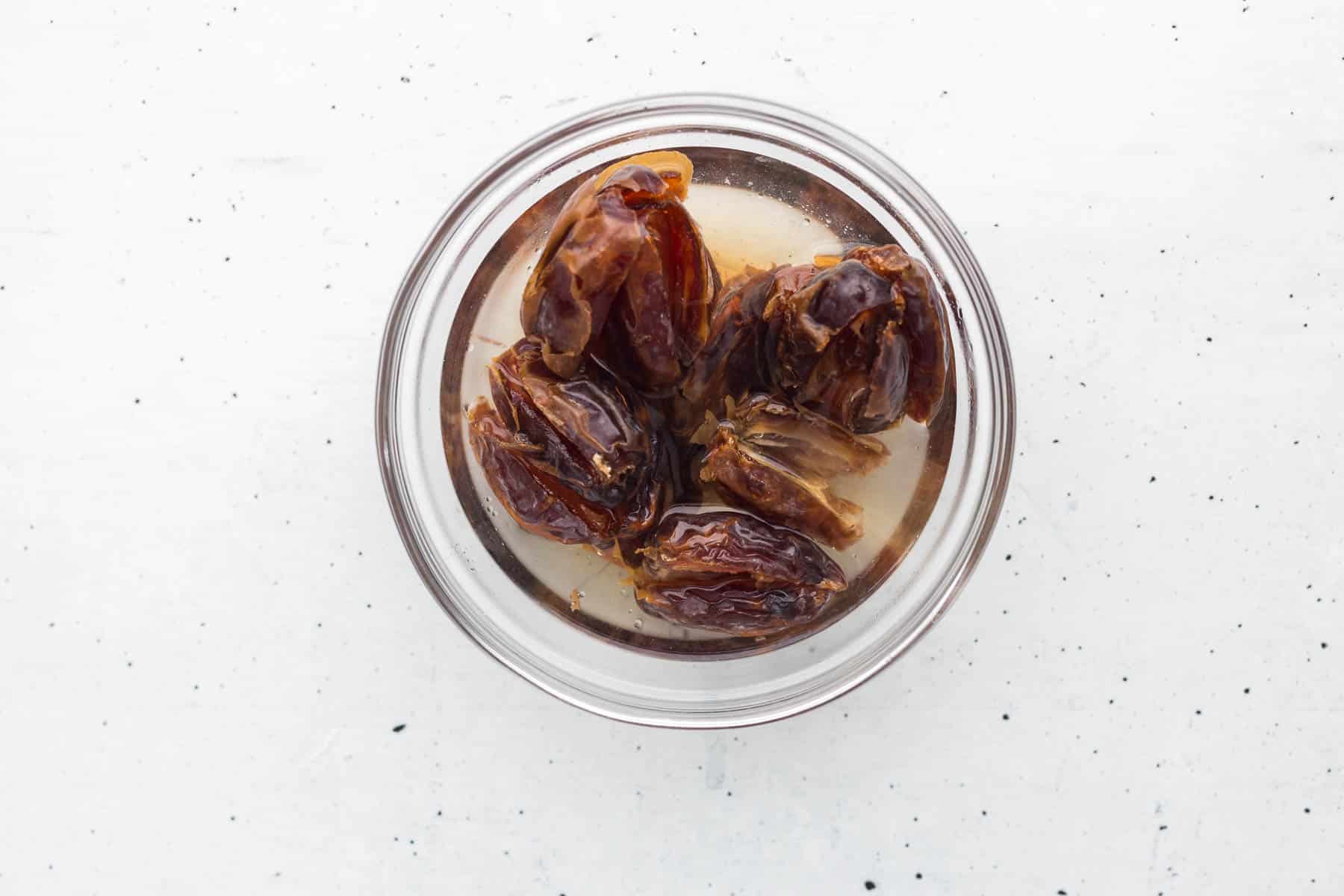 pitted dates & baking soda in bowl with boiling water for date cake