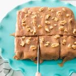 slicing into finished date cake on teal cake stand