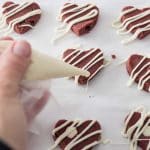 adding drizzle of white chocolate to top of edible red velvet cookie dough hearts