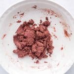dry ingredients mixed in with wet in large white bowl for edible red velvet cookie dough hearts