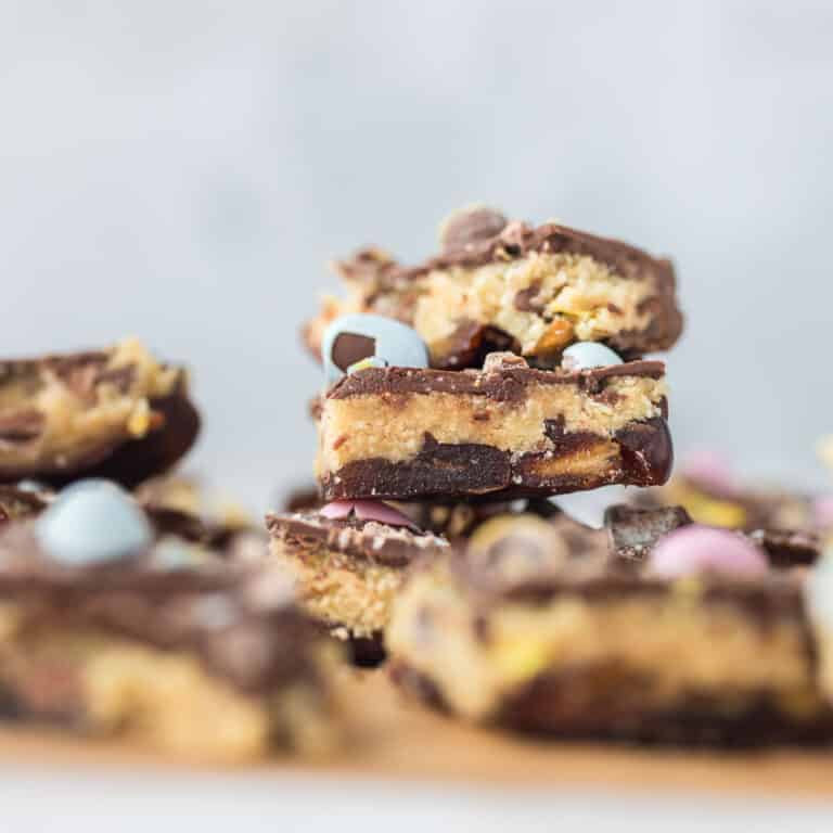 Mini egg cookie dough date bark layered with Medjool dates, cookie dough, chocolate, and crushed mini eggs