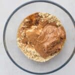 Mixing nut butter, protein powder, almond flour, and maple syrup in a bowl to make mini egg cookie dough protein bar base