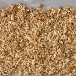 Easy Homemade Healthy Granola pressed down into parchment-lined baking sheet