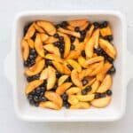 sliced peaches, blueberries, maple syrup, tapioca starch, cinnamon, nutmeg, salt, lemon juice mixed together in 8x8 baking pan