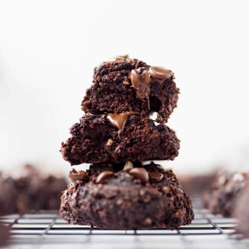 Stack of 3 fudgy banana chocolate cookies on black cooling rack