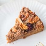 slice of Blackberry Sour Cream Coffee Cake on white plate with gold fork