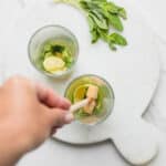Muddling mint leaves, lime and honey until mint is fragrant and the lime releases its juice.