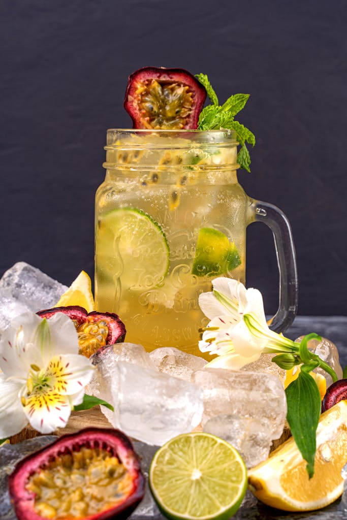 passion fruit mocktail in a mason jar surrounded by ice and flowers.