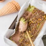 Homemade Dubai chocolate ice cream in a loaf pan topped with pistachio cream, chocolate, pistachios, and toasted kataifi.