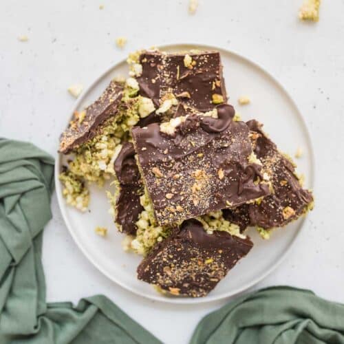 Dubai Chocolate Rice Cake Bars topped with chocolate and crushed pistachios, sliced into squares on white plate