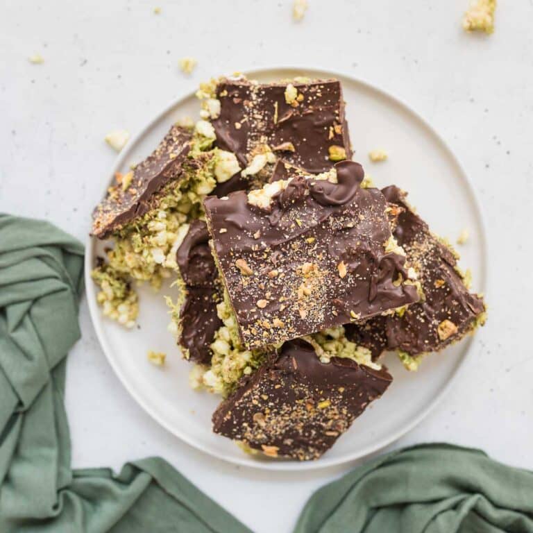 Dubai Chocolate Rice Cake Bars topped with chocolate and crushed pistachios, sliced into squares on white plate