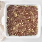 Melted chocolate poured over homemade Dubai Chocolate Rice Cake Bars before chilling.