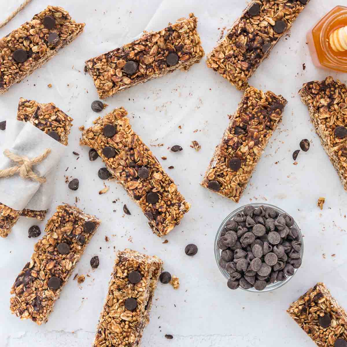 Homemade chocolate chip granola bars with oats and puffed quinoa on white surface